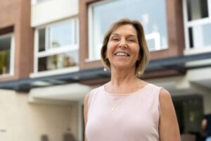 Portrait of senior woman in front of new house HECM for Purchase
