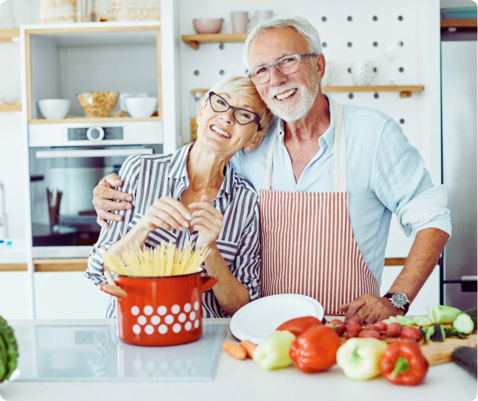 Smiling senior couple preparing food in a bright kitchen at home