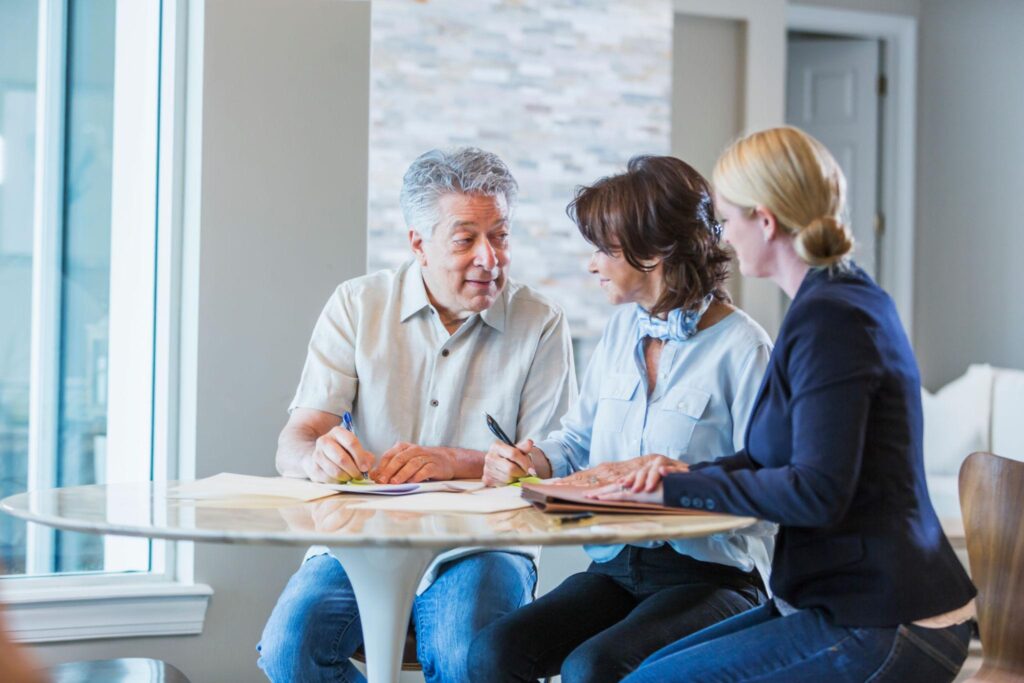 Senior homeowners reviewing long-term care and retirement planning documents at home